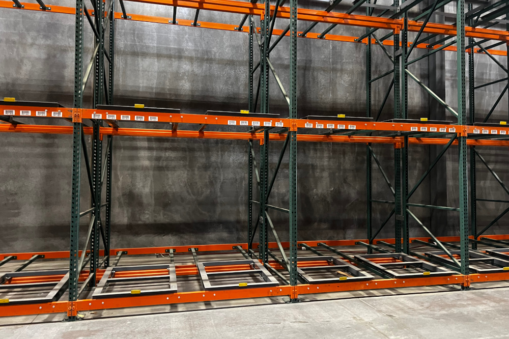 Pushback pallet racking showing cart rails and load beams